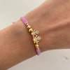 Pulsera tejida con herraje de niñas y circones blancos con balines lisos y diamantados 5mm 4mm y 3mm  Oro amarillo 18k 1,5 Gr