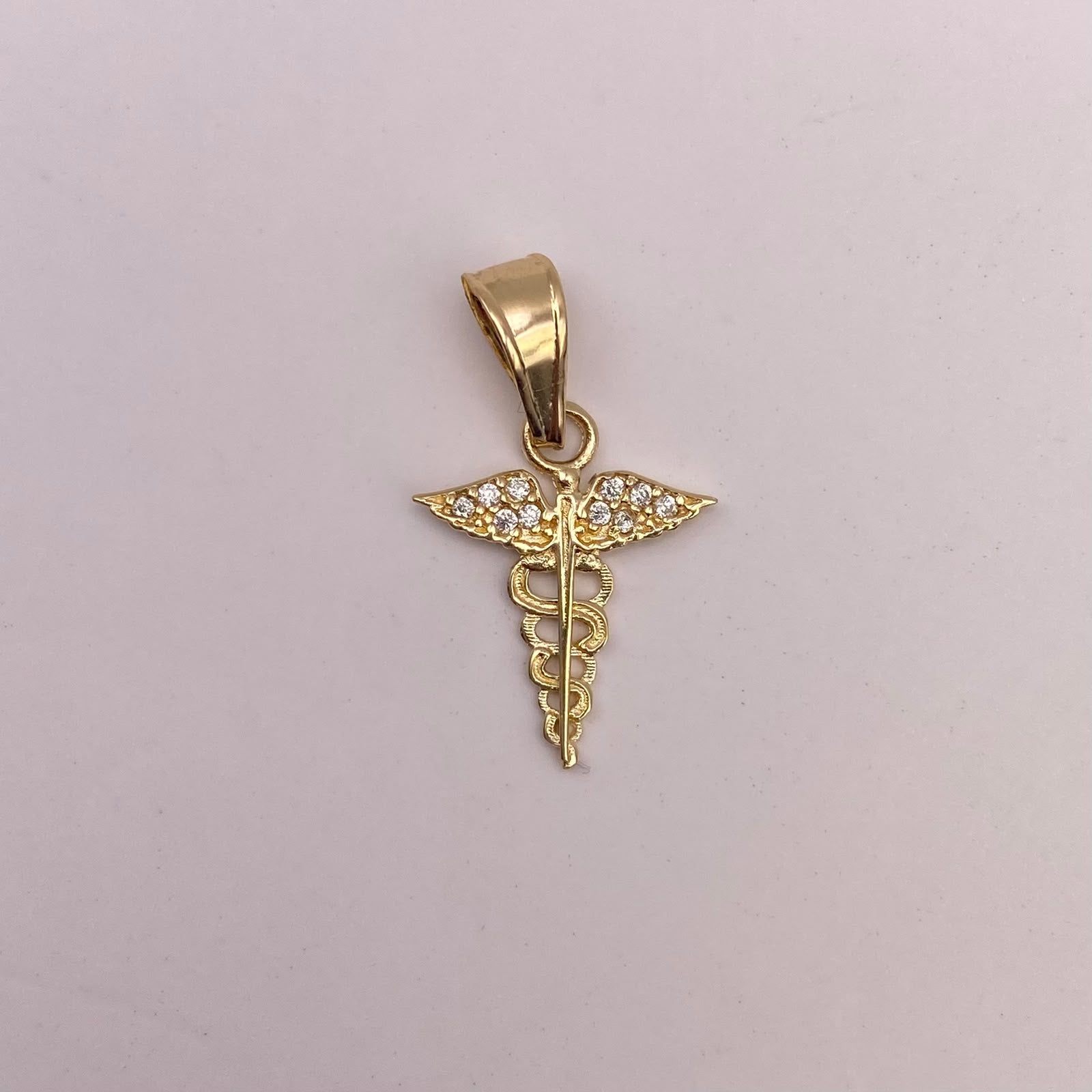 Dije Caduceo con alas y circones blancos Oro amarillo 18k 0,58 Gr / 12,55 mm / 2 Cm