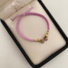Pulsera tejida con herraje de niñas y circones blancos con balines lisos y diamantados 5mm 4mm y 3mm  Oro amarillo 18k 1,5 Gr