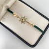 Pulsera tejida con herraje de timon con circones verdes  Oro amarillo 18k 3,1 Gr